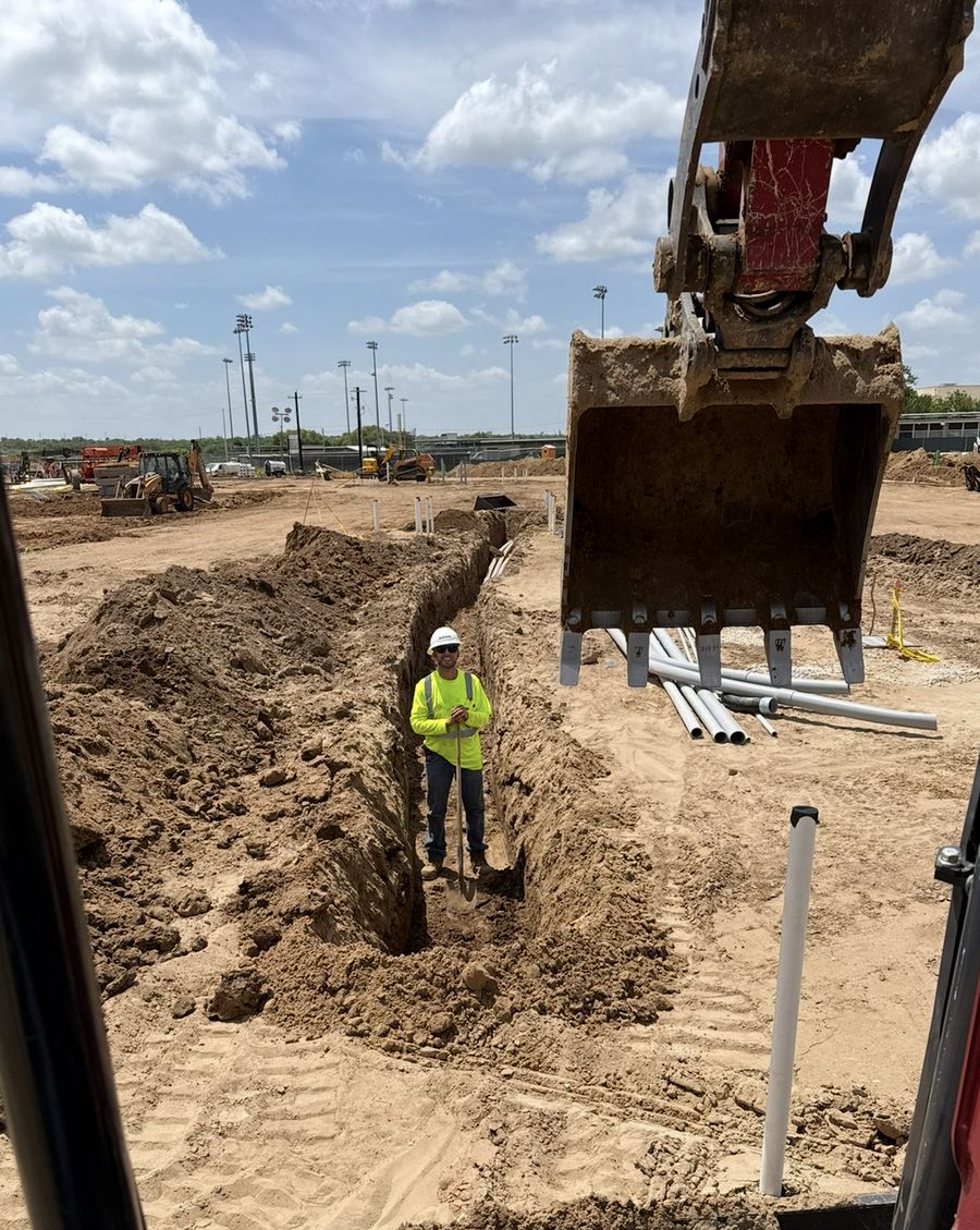 Excavator cutting a utility trench on a commercial development site near San Antonio, Texas