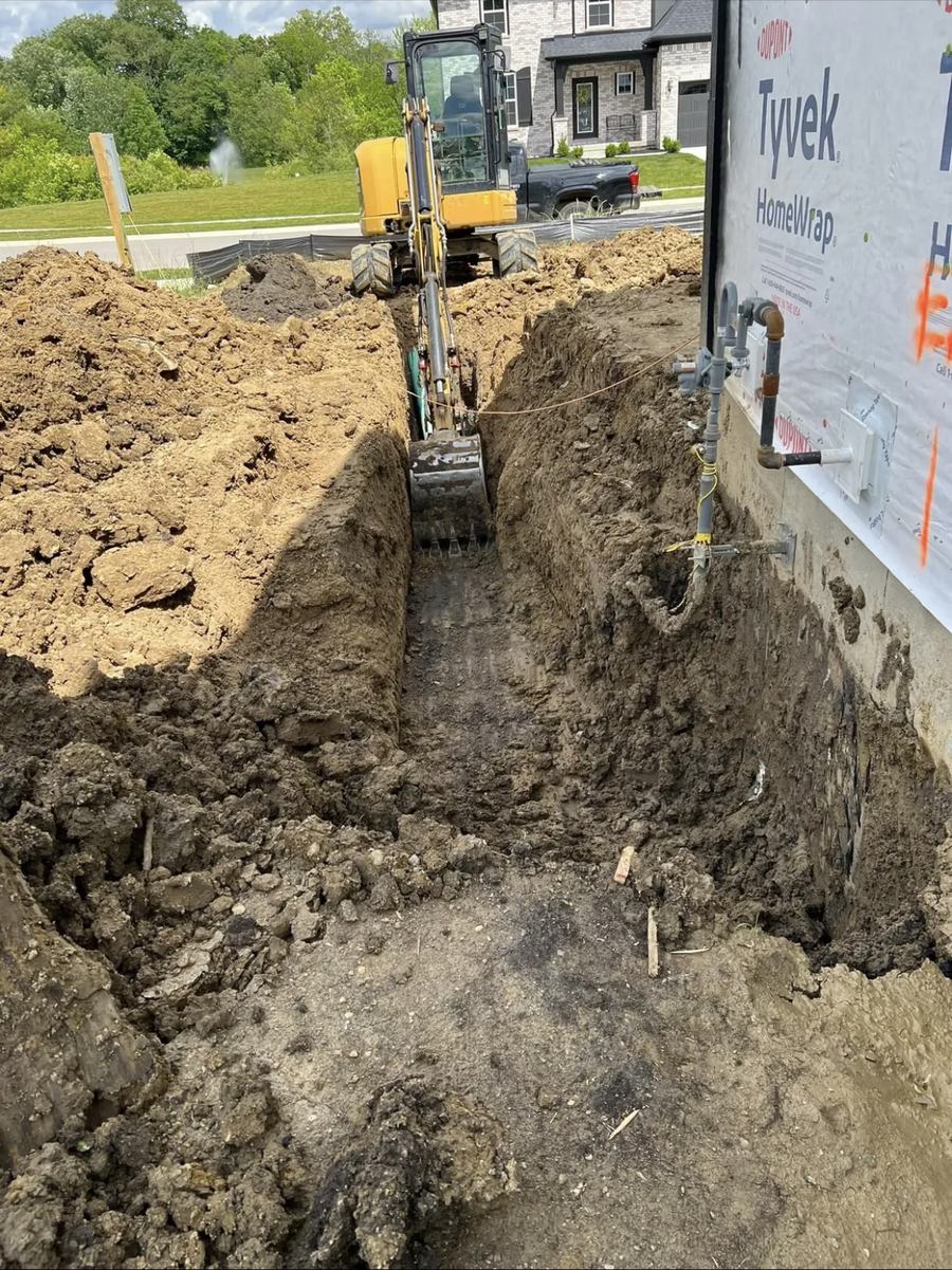 Foundation and utility trench excavated alongside a new home under construction