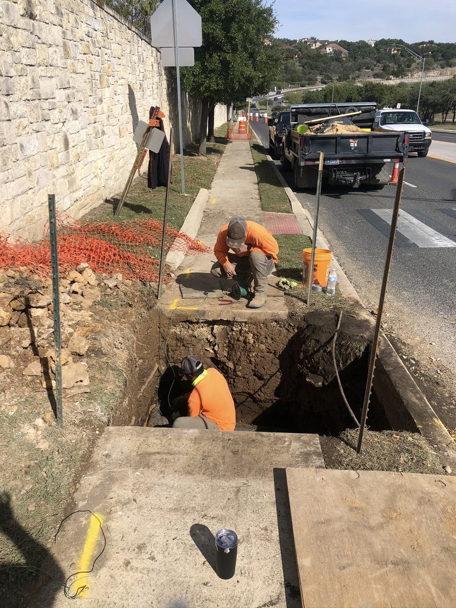 Roadside utility excavation and sidewalk restoration on a South Texas street